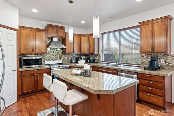 a kitchen with stainless steel appliances granite countertop a sink a stove and a refrigerator