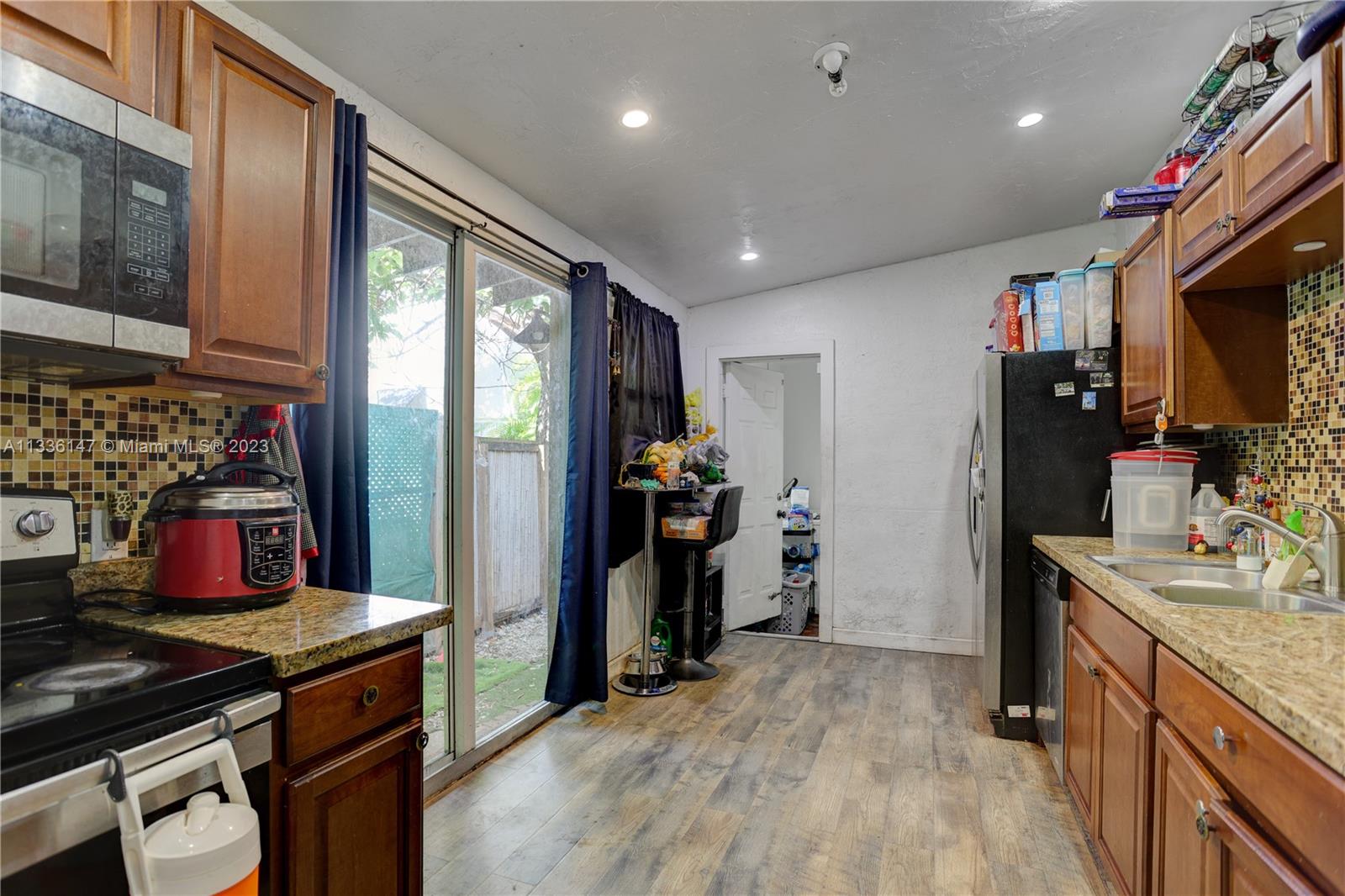 980 Southwest 15th Avenue Miami, FL 33135 - Photo 12 of 23 a kitchen that has a lot of cabinets a sink and wooden floor