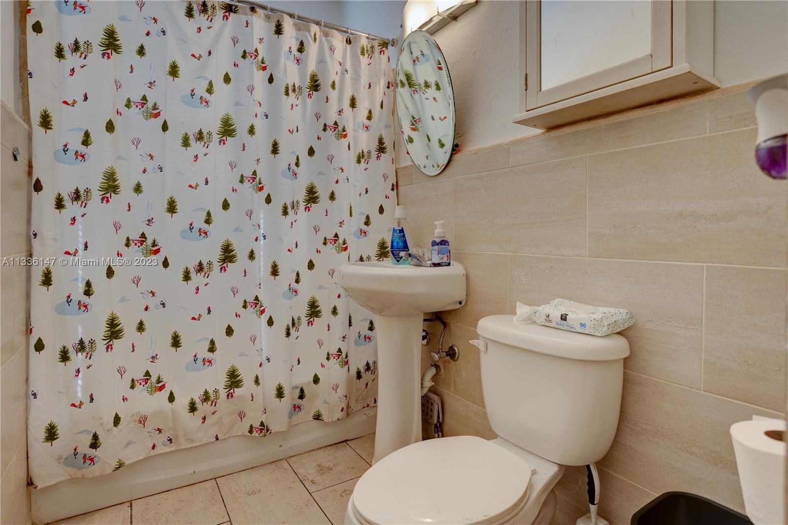 980 Southwest 15th Avenue Miami, FL 33135 - Photo 18 of 23 a white toilet sitting next to a shower curtain