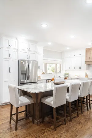 a dining hall with stainless steel appliances kitchen island granite countertop a dining table and chairs