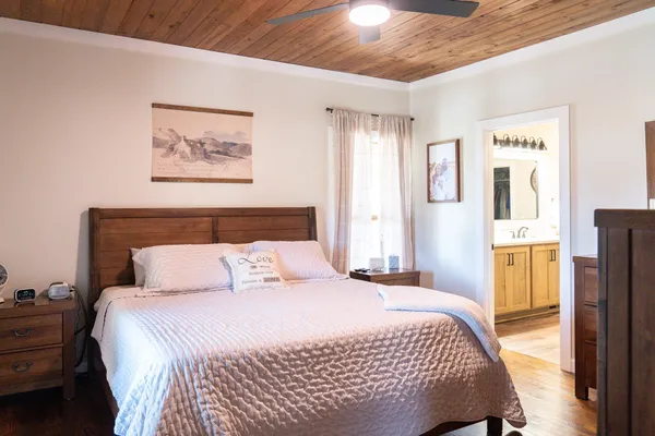 a bedroom with a bed and wooden floor