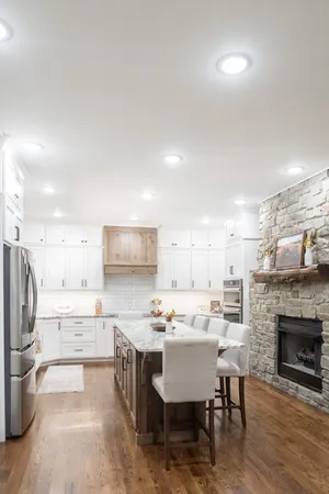 a kitchen with a dining table chairs refrigerator and cabinets