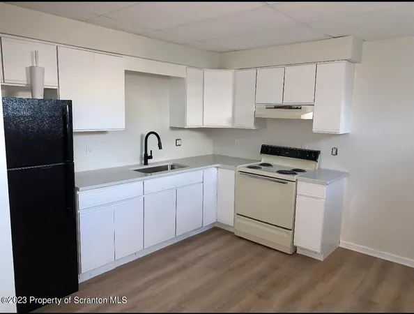 a kitchen with appliances a sink and cabinets