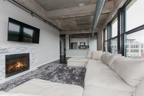 a living room with furniture a flat screen tv and a fireplace