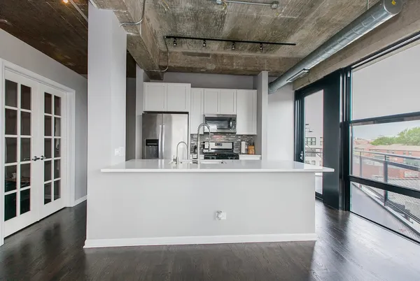 a kitchen with stainless steel appliances granite countertop a refrigerator a stove and a sink with cabinets