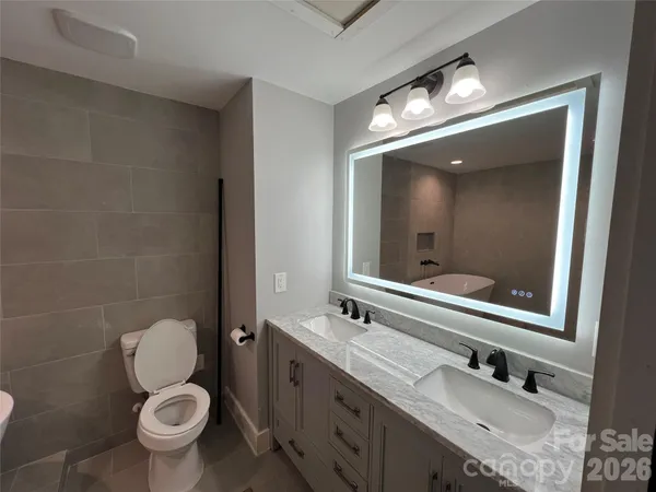 a bathroom with a toilet sink and mirror