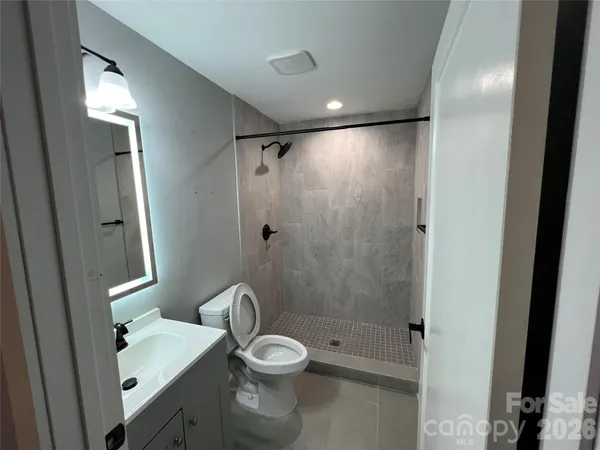 a bathroom with a shower a sink and toilet