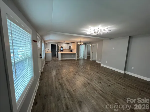 a view of a livingroom with hardwood floor and a kitchen