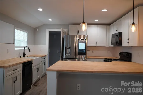 a kitchen with stainless steel appliances a sink a stove a refrigerator and cabinets