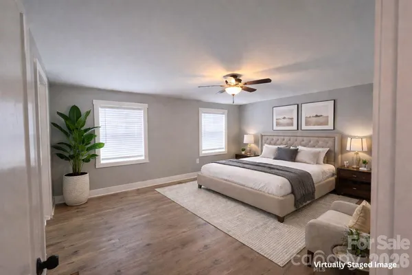 a spacious bedroom with a large bed and a chandelier