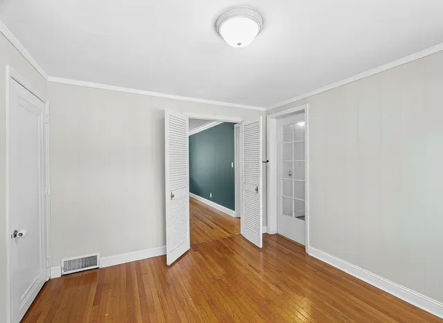 a view of an empty room with wooden floor