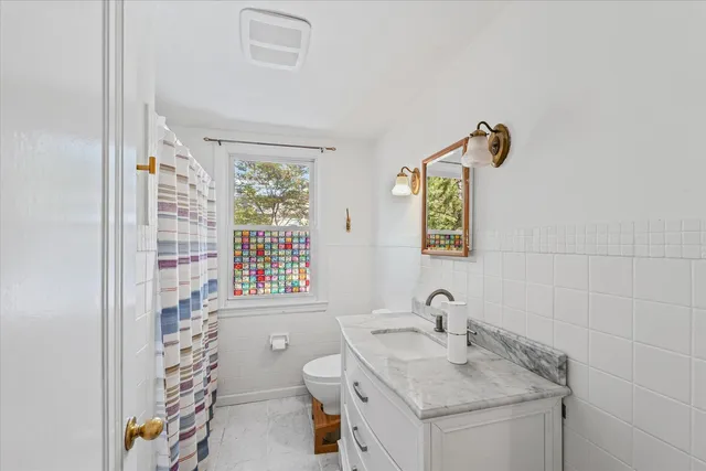 a bathroom with a granite countertop sink toilet a mirror and shower