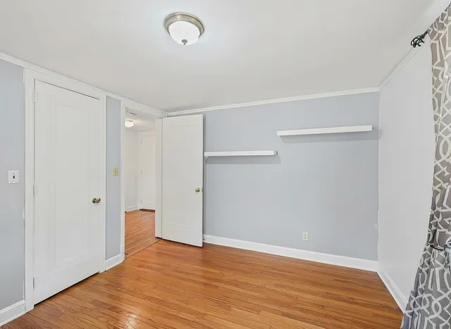 a view of an empty room with wooden floor