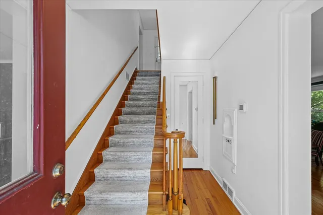 a view of a hallway with wooden floor and staircase