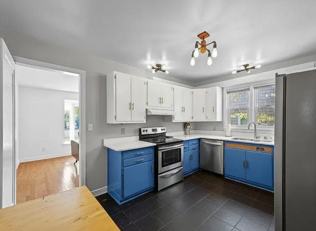 a kitchen with stainless steel appliances granite countertop stove top oven and cabinets