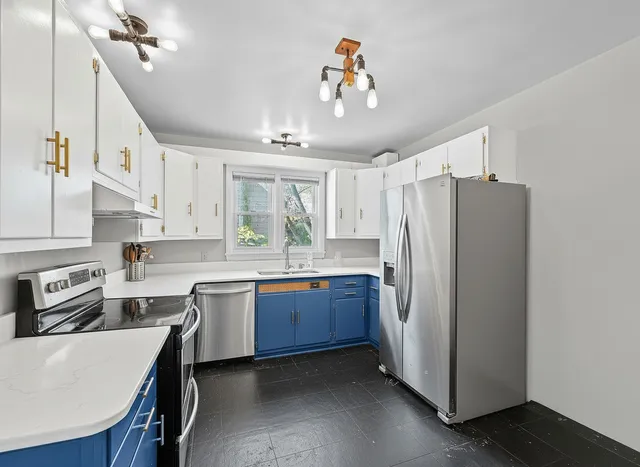 a kitchen with stainless steel appliances granite countertop a refrigerator a sink dishwasher a stove and a dining table with wooden floor