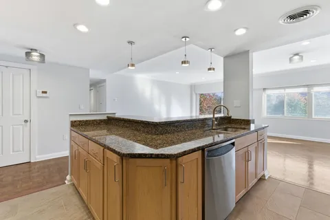 a kitchen with stainless steel appliances granite countertop a sink and a stove