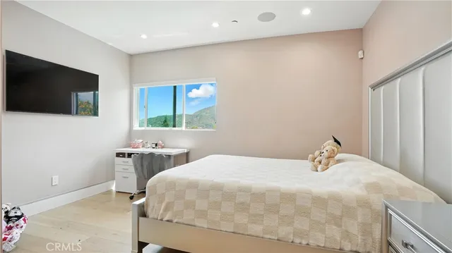 a bedroom with a bed and a flat tv screen