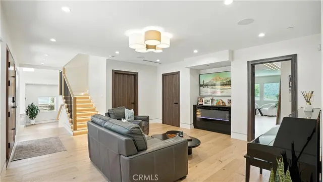 a living room with furniture a chandelier and a flat screen tv