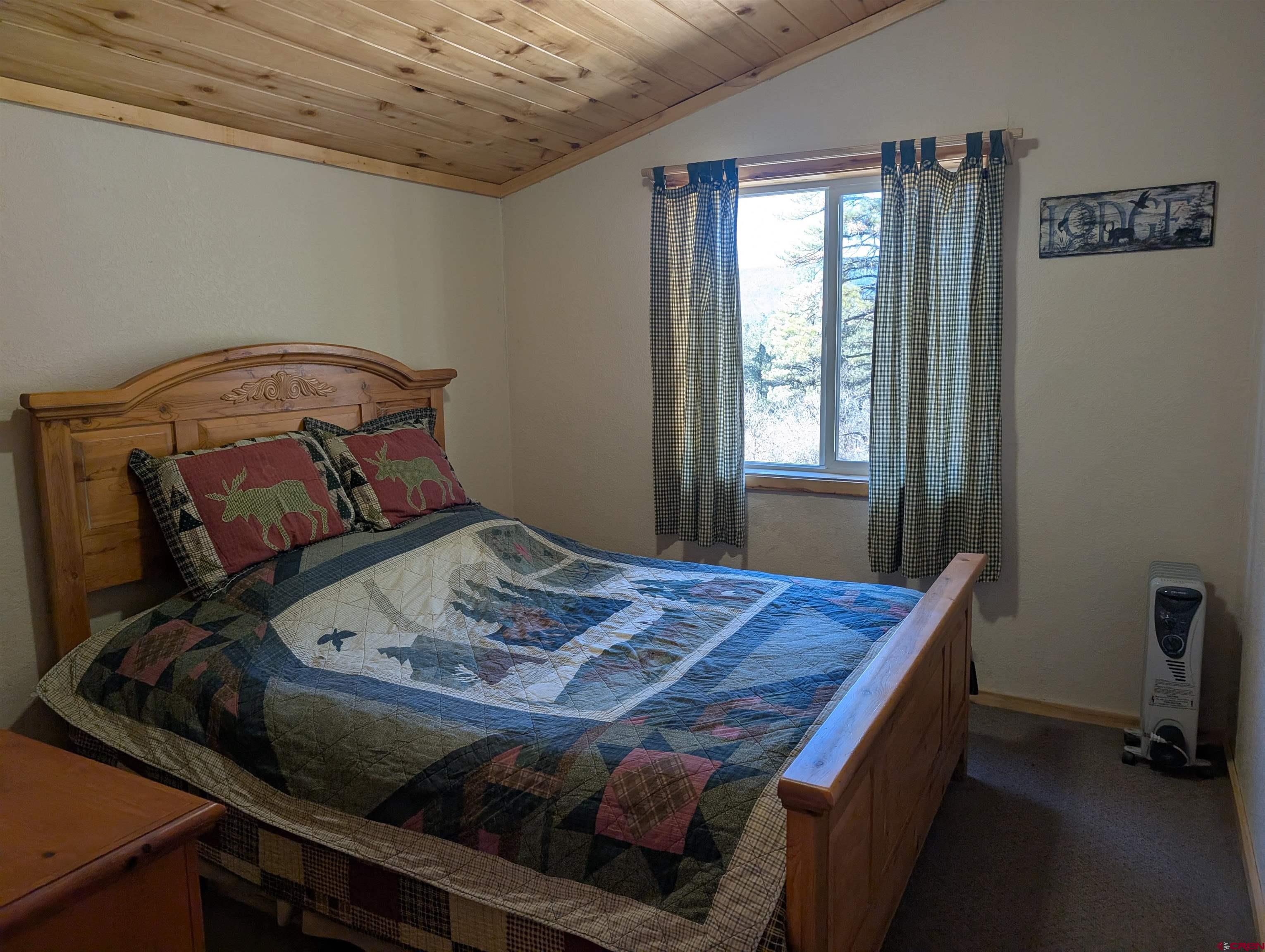 472 Haystack Circle Pagosa Springs, CO 81147 - Photo 26 of 34 a bed sitting in a bedroom next to a window