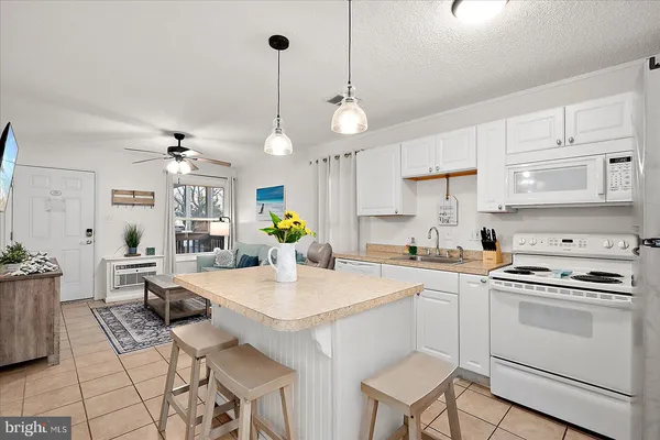 a kitchen with a stove a chandelier a dining table and chairs