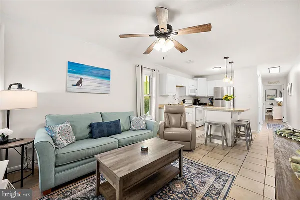 a living room with furniture kitchen view and a chandelier