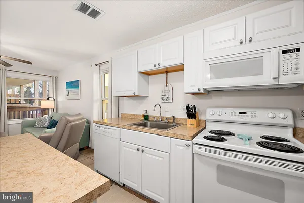 a kitchen with a stove a sink a refrigerator and cabinets