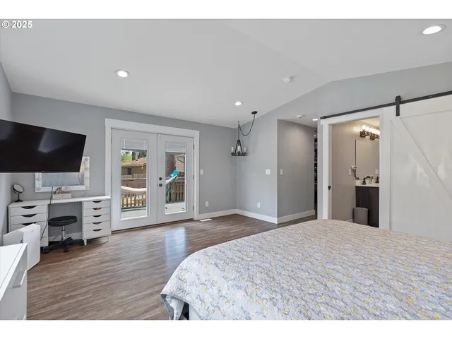 a spacious bedroom with a bed and a flat screen tv