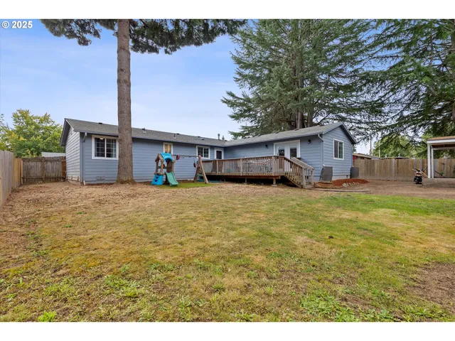 a front view of house with yard and trees in the background