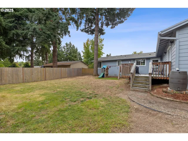 a view of a house with backyard and a tree