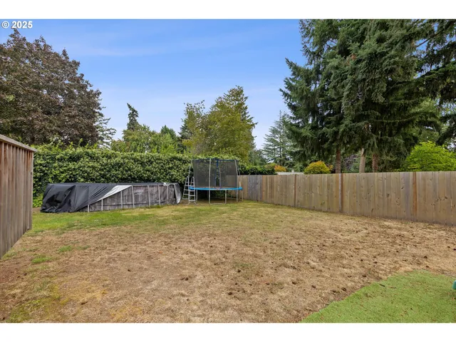 a view of backyard with wooden fence