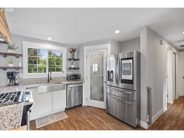 a kitchen with stainless steel appliances granite countertop a refrigerator and a sink