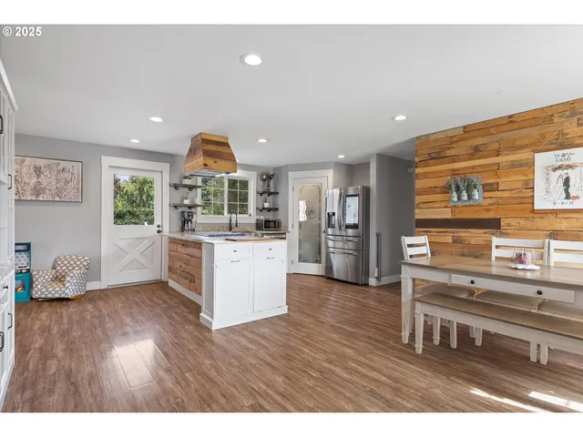 a kitchen with stainless steel appliances kitchen island granite countertop a refrigerator and a stove top oven