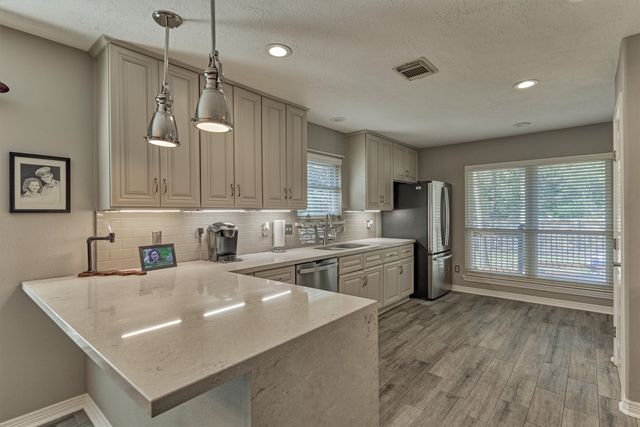 a kitchen with kitchen island white cabinets and stainless steel appliances