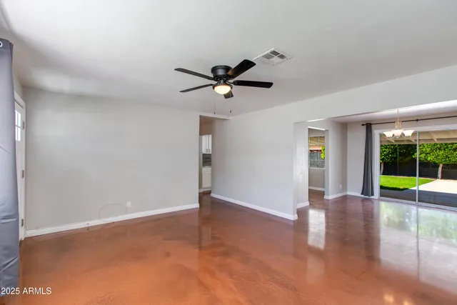 a view of an empty room with window and wooden floor