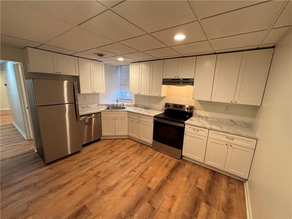 a kitchen with a refrigerator sink and cabinets