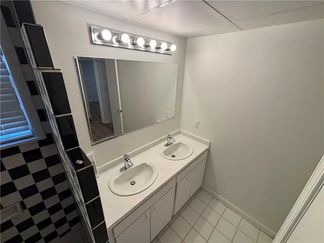 a bathroom with a sink a toilet a mirror and shower