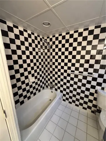a bathroom with a black and white checkered floor