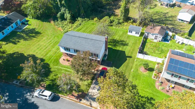 an aerial view of a house with a yard and swimming pool