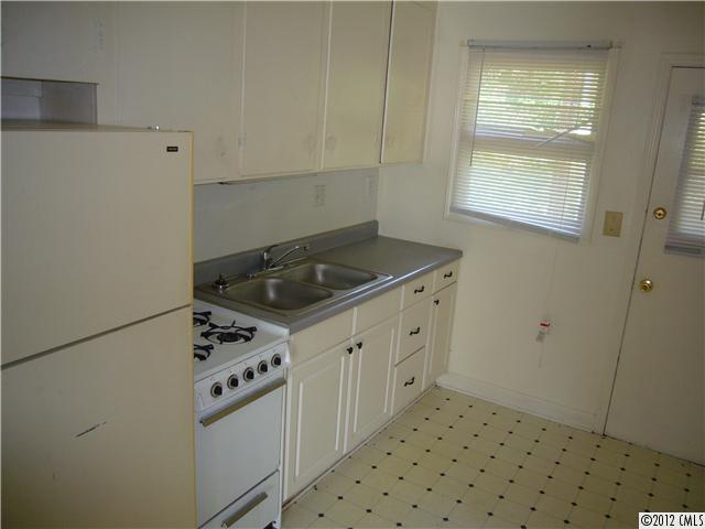 3834 Tuckaseegee Road, Unit 3 Charlotte, NC 28208 - Photo 3 of 3 a kitchen with granite countertop white cabinets and white appliances