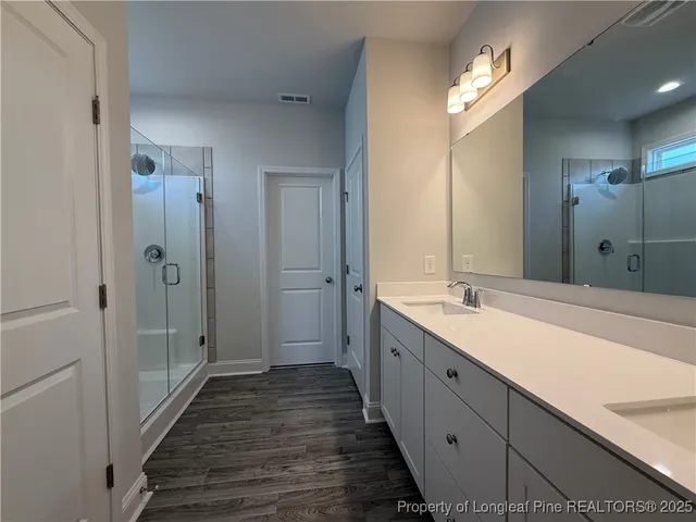 a spacious bathroom with a double vanity sink and mirror