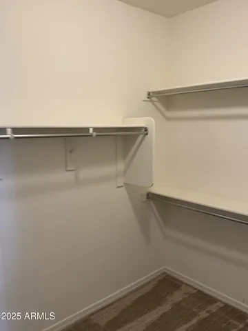 a view of a room with a ceiling fan and a hardwood