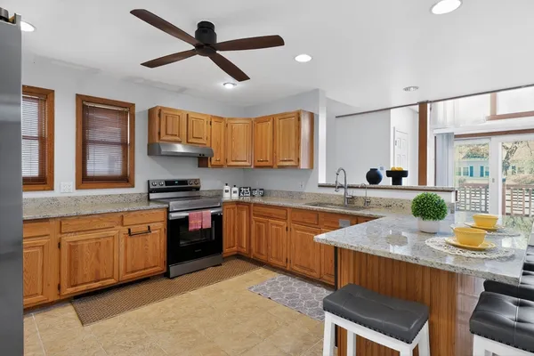 a kitchen with granite countertop a stove sink and cabinets