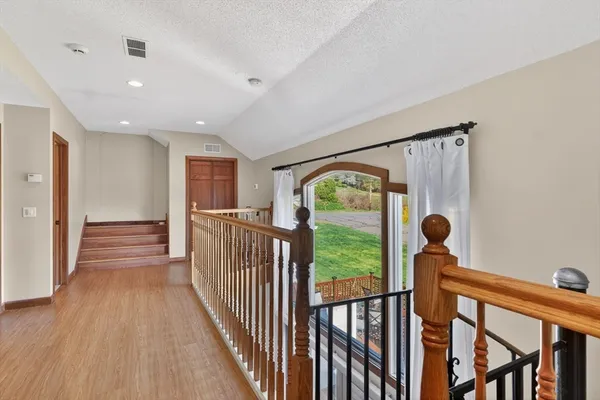 a view of a hallway with wooden floor and stairs