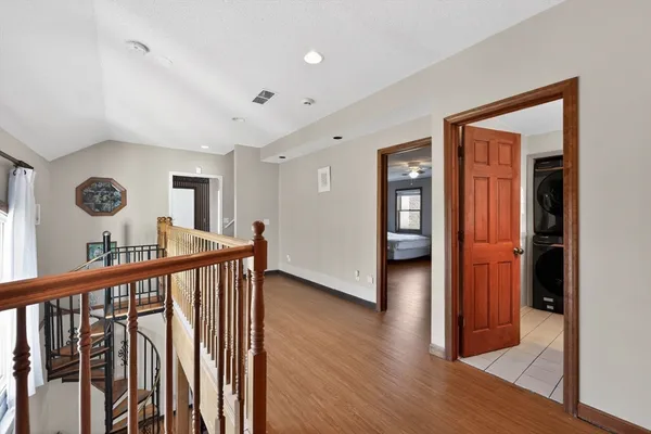 a view of a hallway with wooden floor and stairs