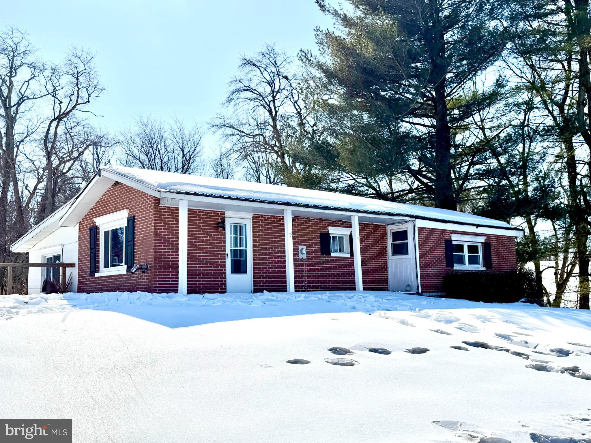 Charming brick home nestled in winter's embrace.