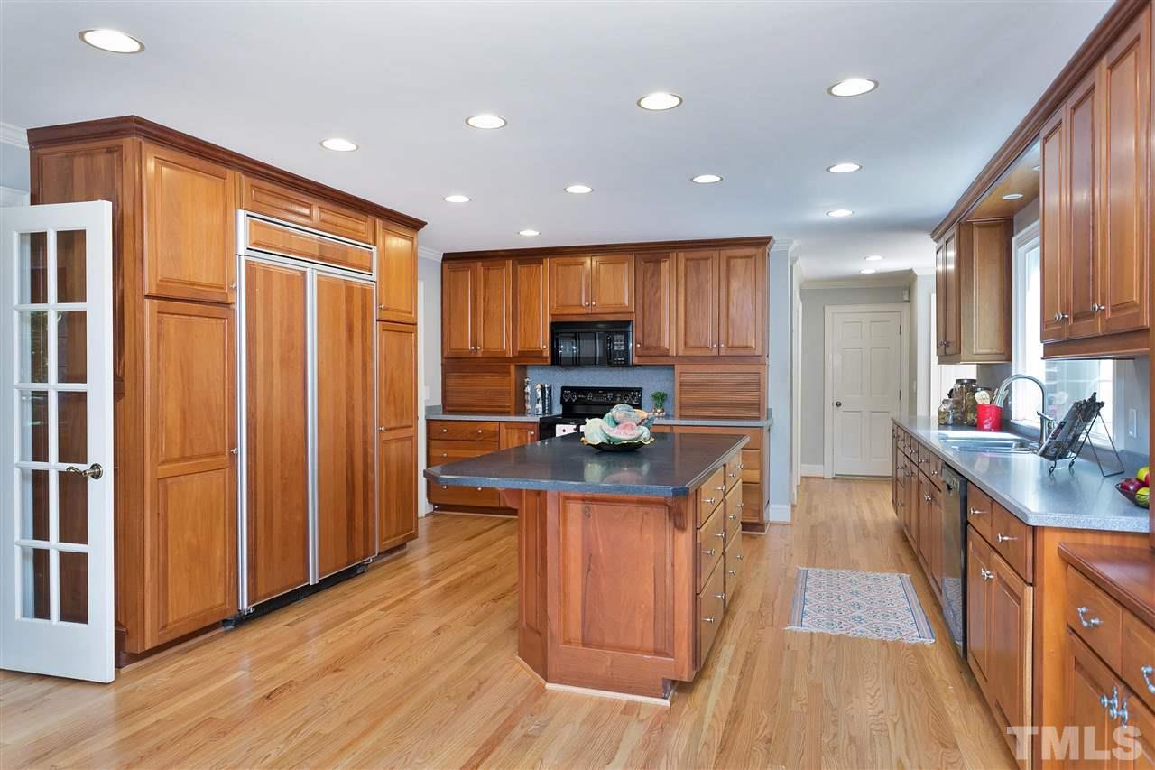 305 Queensferry Road Cary, NC 27511 - Photo 3 of 28 a kitchen with counter top space a sink wooden floor and stainless steel appliances