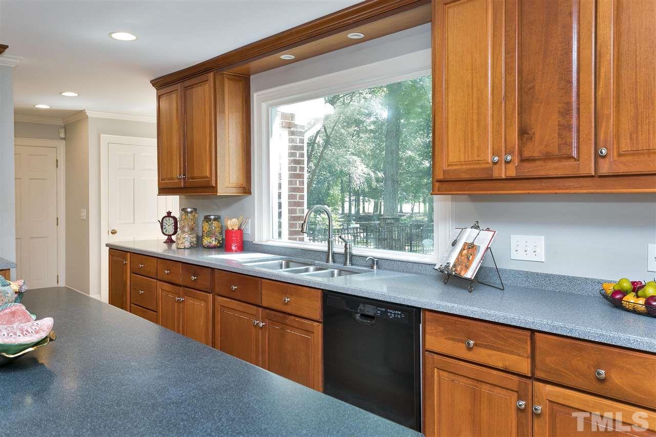 305 Queensferry Road Cary, NC 27511 - Photo 5 of 28 a kitchen with stainless steel appliances granite countertop a sink a stove and a wooden cabinets