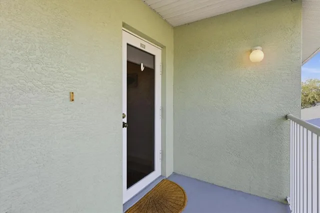 a view of a hallway with wooden floor and a bathroom