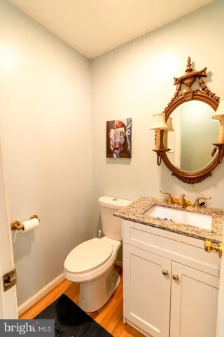 a bathroom with a granite countertop sink mirror vanity and toilet